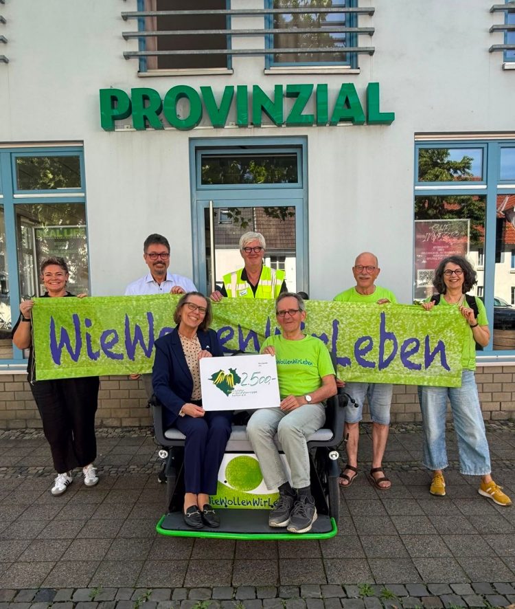 Dr. Katrin Peitz (links auf dem Fahrrad - Provinzialer helfen) bei der Spendenübergabe an den Verein WieWollenWirLeben e.V.
