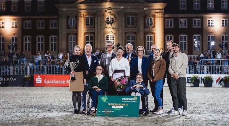 Patric Fedlmeier (2. v. l. - Stellvertretender Vorstandsvorsitzender Provinzial Versicherung) bei der Spendenübergabe mit Dr. Katrin Peitz (5. v. r. - Provinzialer in Westefalen-Lippe helfen e.V.) an Horses für Heroes e.V. vor dem Schloss in Münster im Rahmen des Turnier der Sieger.